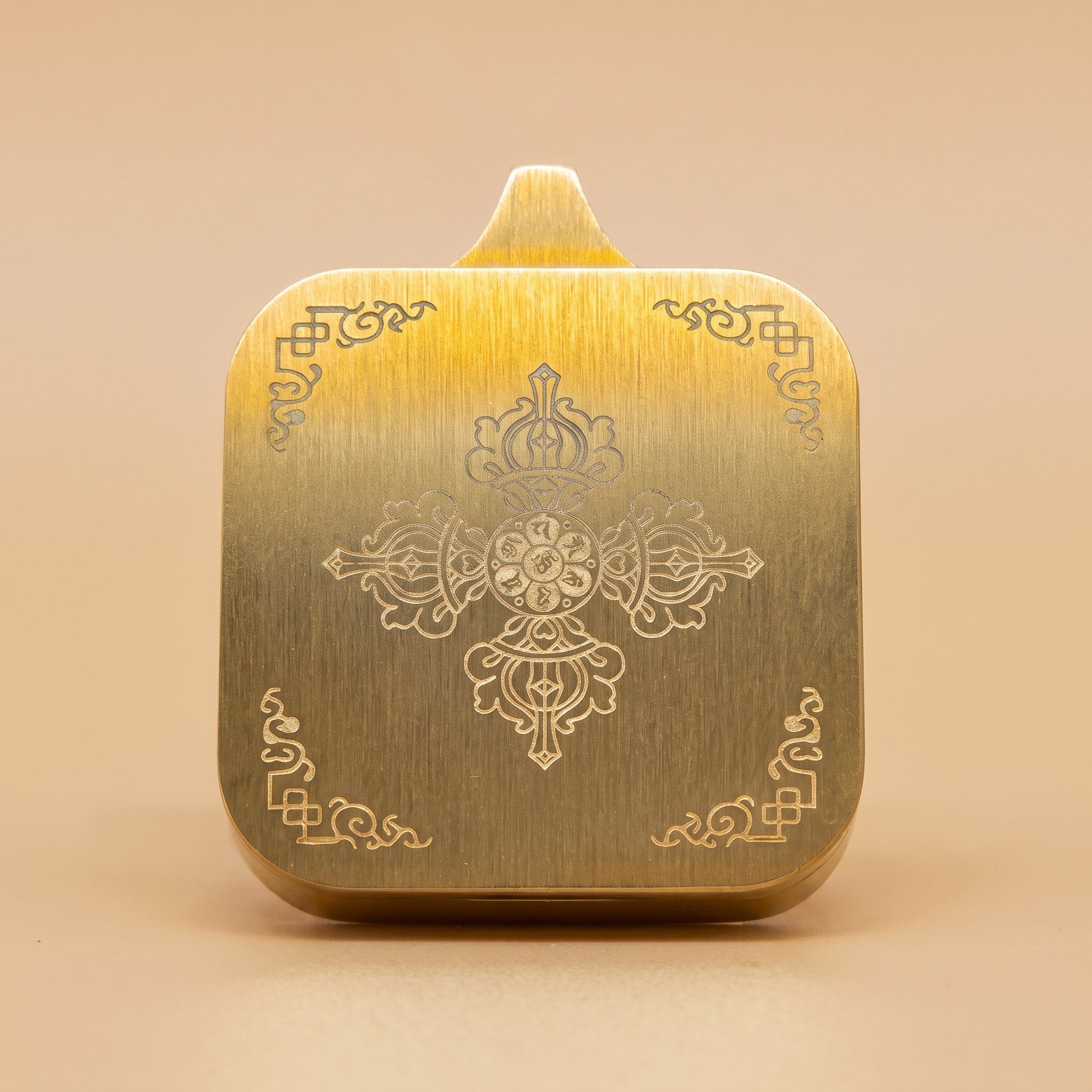 藥師佛手繪描金佛牌背面圖，展示金色拉絲背面、中央法器浮雕圖案及四角紋飾