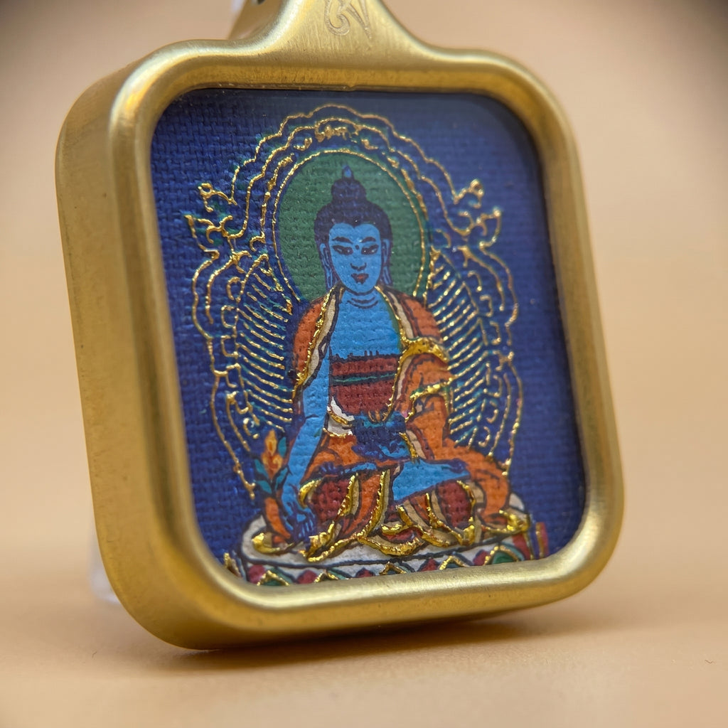 藥師佛手繪描金佛牌近鏡圖，特寫藍色佛面、金色描線、佛光背紋及手繪細節