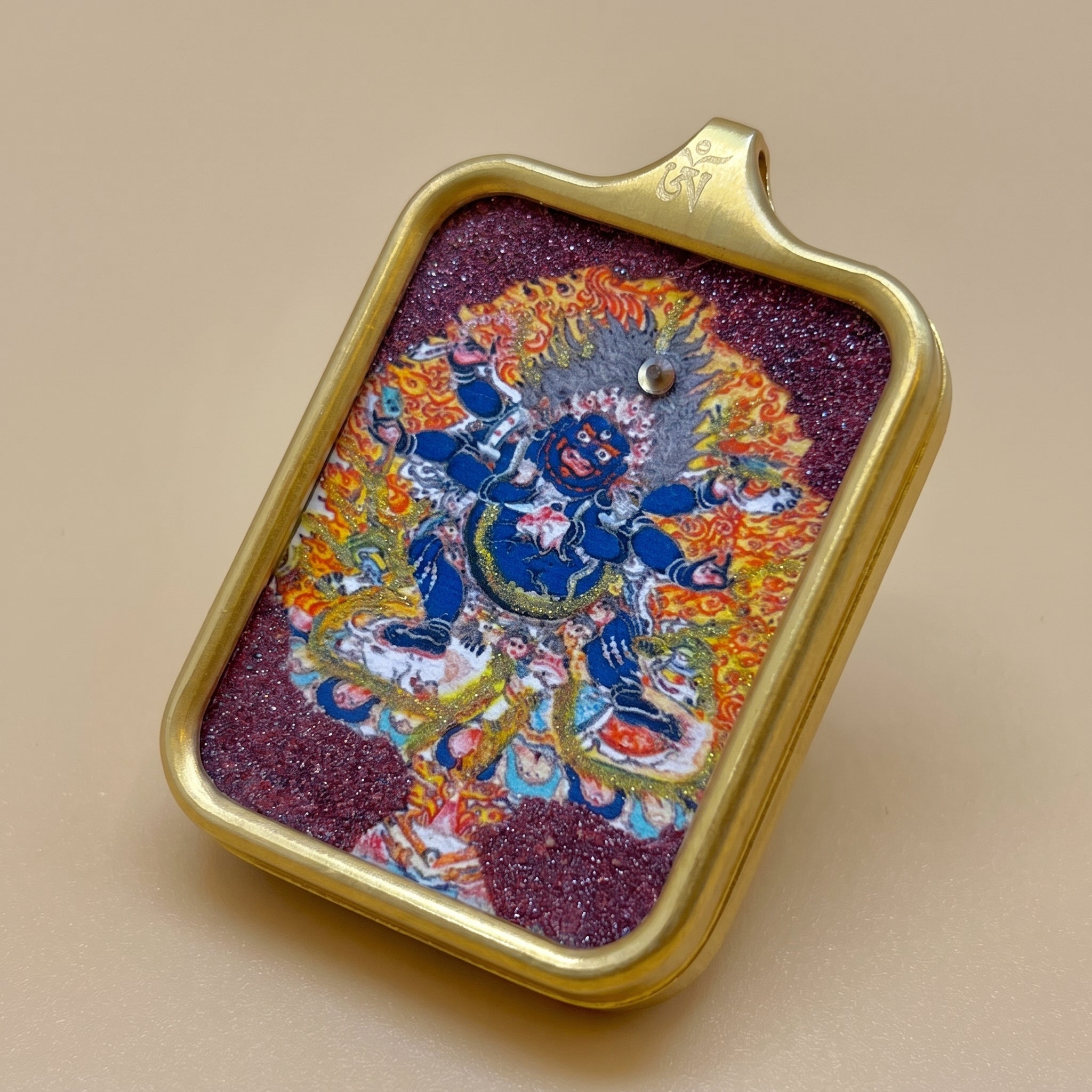 六臂大黑天手繪朱砂描金佛牌斜角展示圖，呈現佛牌厚度、金色金屬框、頂部掛扣及朱砂描金正面細節