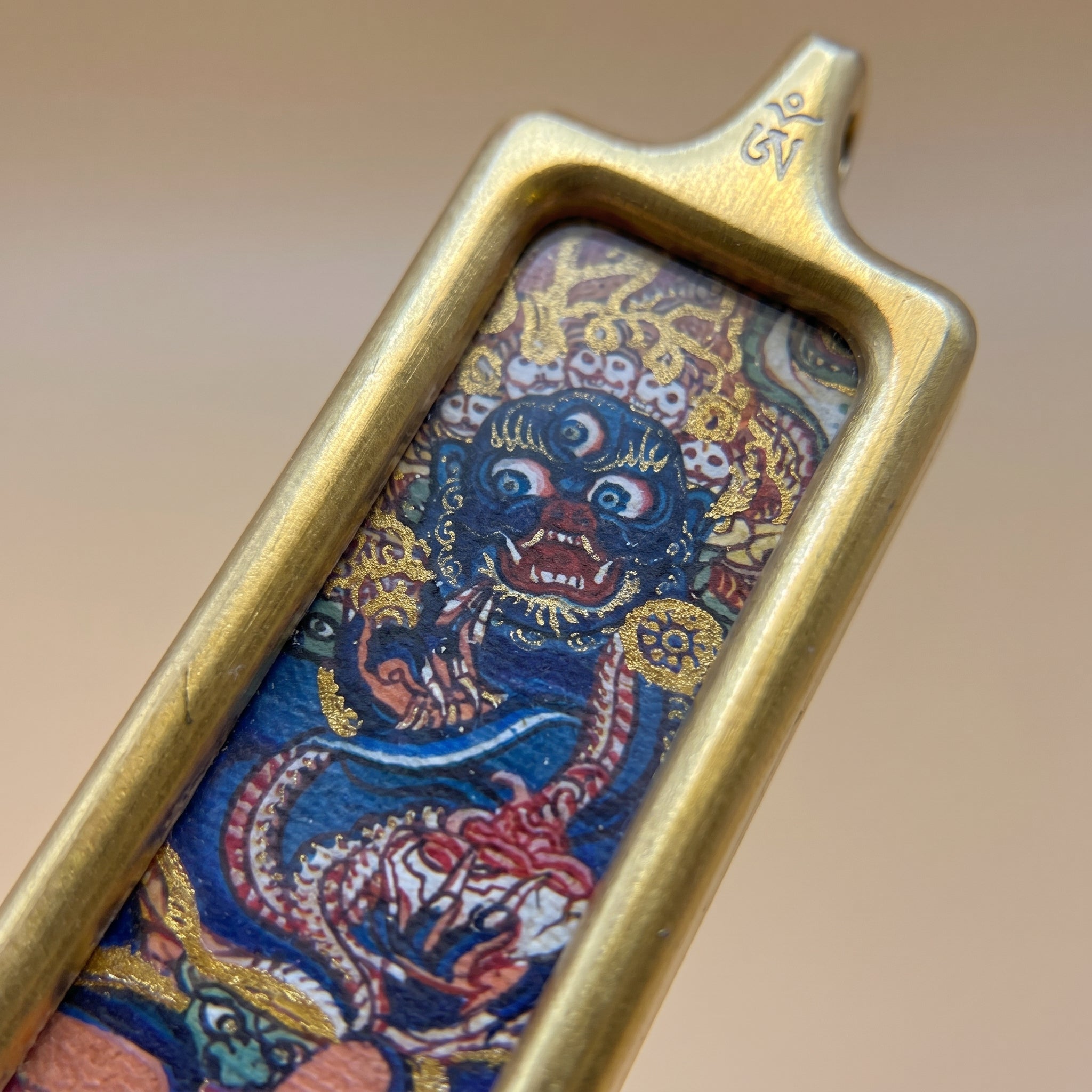 六臂大黑天長方形手繪描金佛牌近鏡細節圖，特寫護法法相、金色框邊、手繪線條及佛牌表面質感