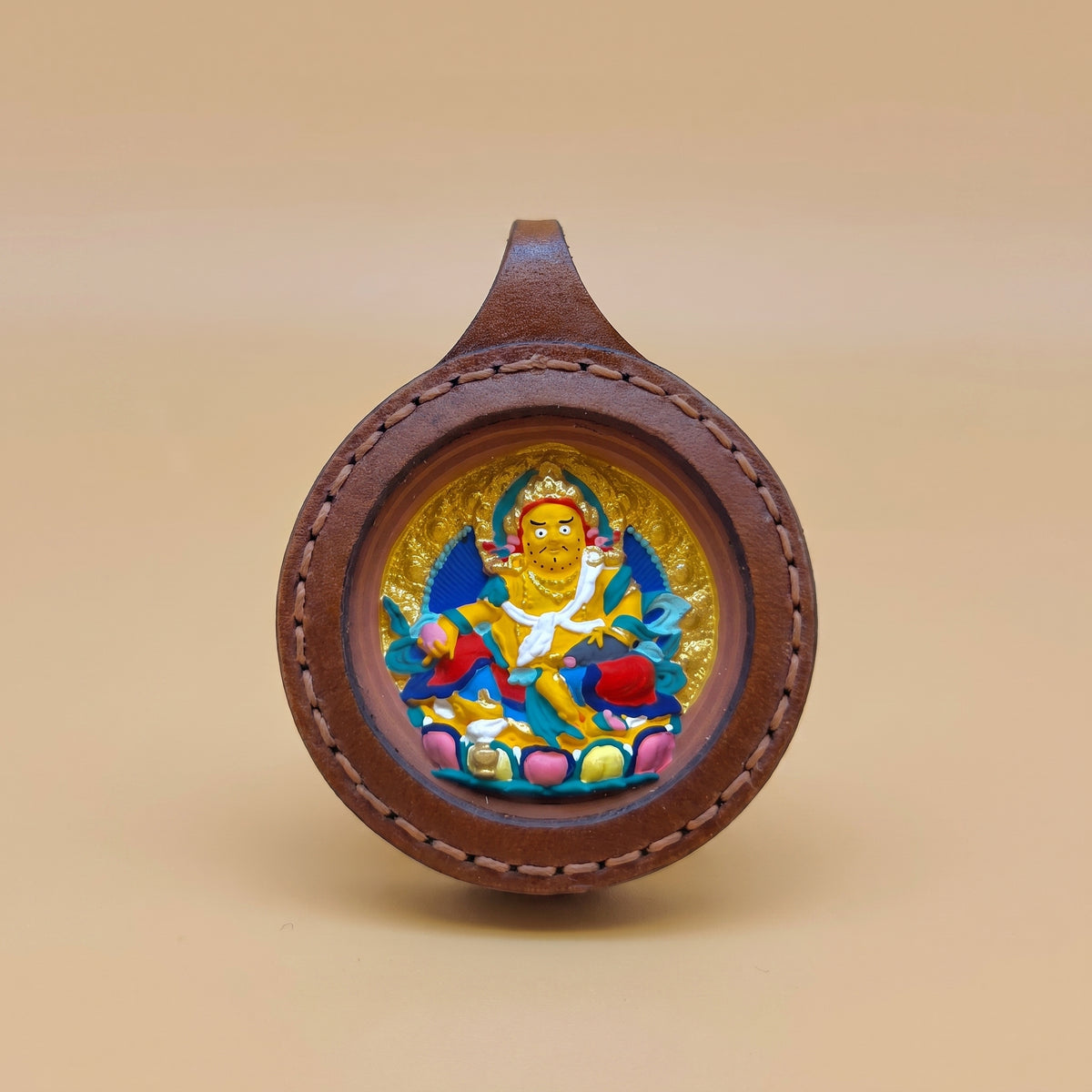 黃財神佛牌真皮框手繪泥牌正面圖，黃財神法相色彩鮮明，圓形真皮框與手工細節清楚展示。