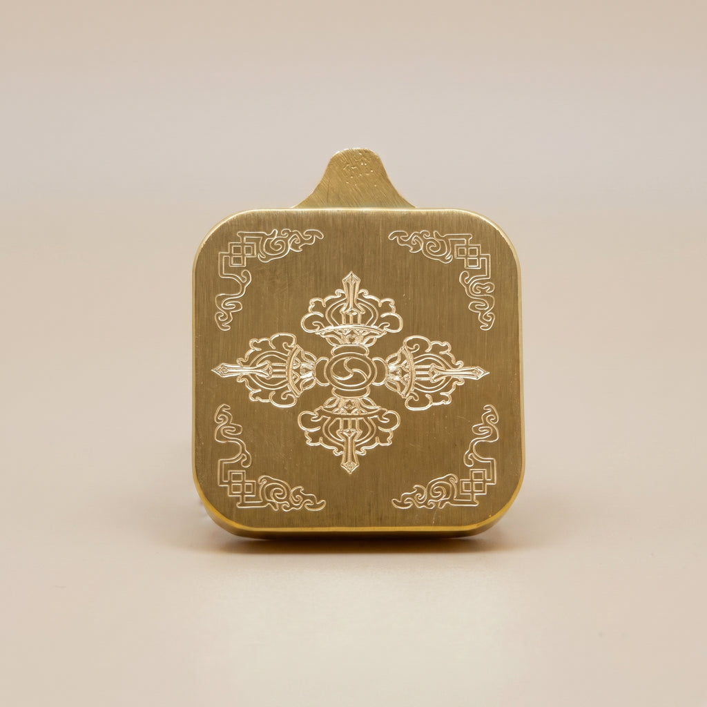 扎基拉姆手繪描金佛牌背面圖，展示金色拉絲背面、中央法器浮雕圖案、四角紋飾及佛牌厚度